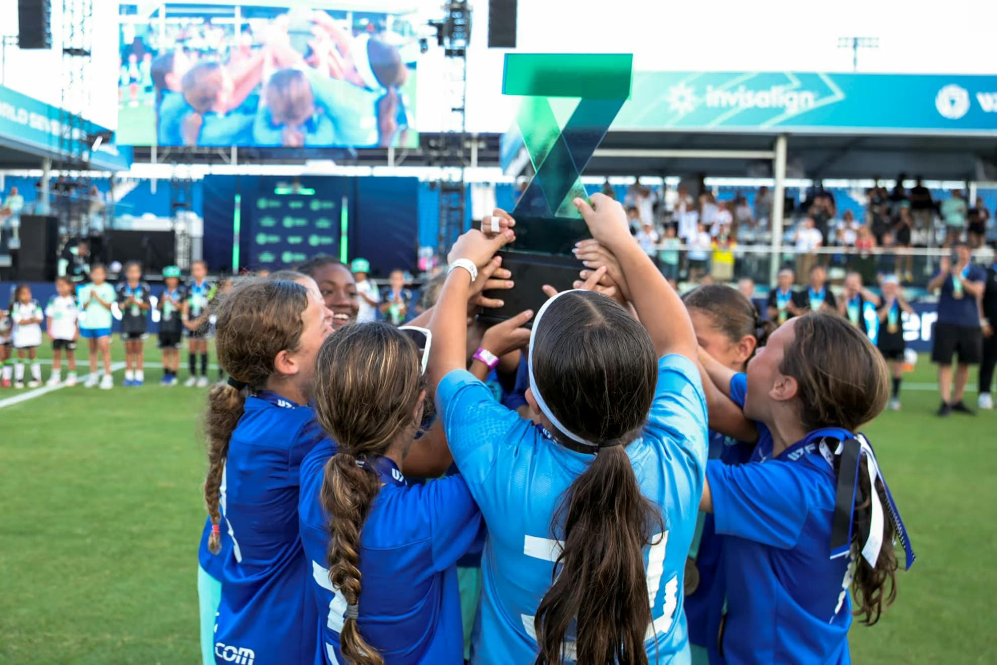Youth Soccer team raising the world sevens football rising sevens trophy